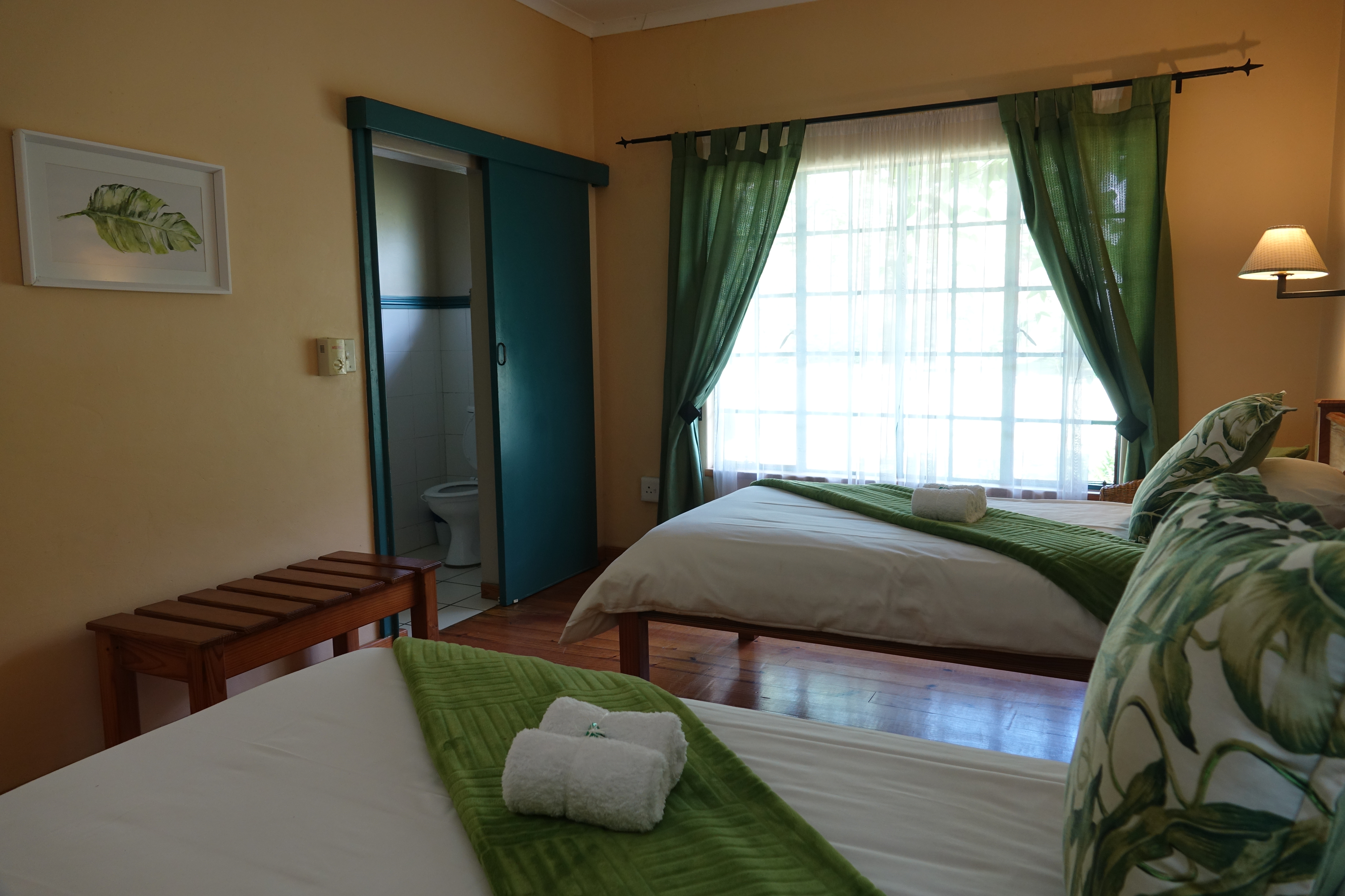 An inside look at one of the beautifully furnished bedrooms at Ekukhanyeni, featuring two single beds